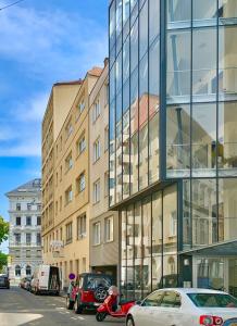 un edificio de cristal con coches estacionados frente a él en Luxurious city apartment incl garage and terrace, en Viena