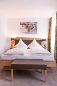 a bedroom with a large bed with a wooden headboard at Brauerei-Gasthof Reichsadler in Mögglingen