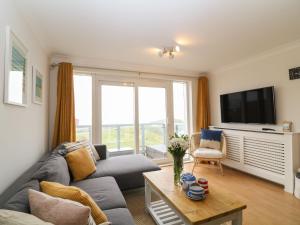 ein Wohnzimmer mit einem Sofa und einem TV in der Unterkunft Breakers in Newquay