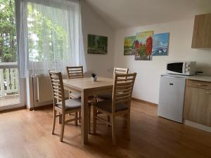 a kitchen with a table with chairs and a microwave at Aqua in Dunajská Streda
