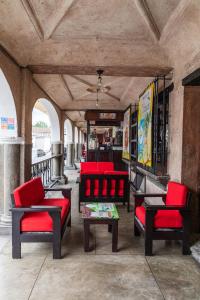a group of red chairs and tables on a porch at Hotel La Sin Ventura in Antigua Guatemala