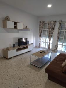 a living room with a couch and a tv at Luz y Sol San Fernando in San Fernando