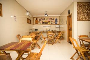 a dining room with wooden tables and chairs at HOTEL POUSADA DAS ROSAS in Carolina