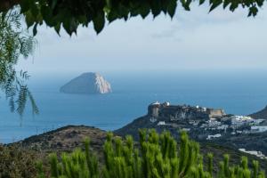 an island in the ocean with a castle on a hill at Villa Iris in Livadi