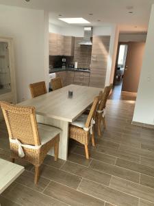 una cucina con un grande tavolo in legno e sedie di Residentie Valauris a Middelkerke
