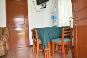 ein Esstisch mit zwei Stühlen und einem blauen Tisch in der Unterkunft Hotel gallego in Campeche