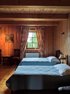a bedroom with a large bed and a window at Kaimo sodyba Senas rublis in Pesčiai