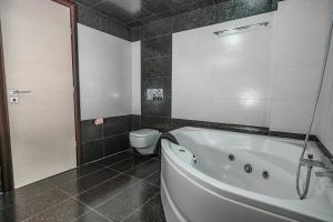 a bathroom with a bath tub and a toilet at Villa Iris in Livadi