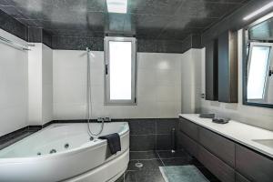 a black and white bathroom with a tub and a sink at Villa Iris in Livadi