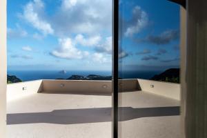 a view of the ocean from the window of a house at Villa Iris in Livadi