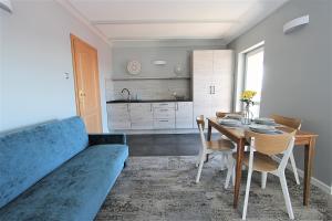 a living room with a blue couch and a table at Villa Stawros in Łeba