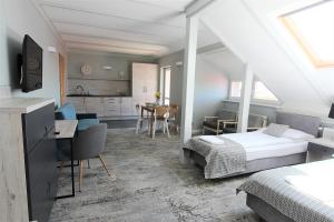 a bedroom with two beds and a desk and a kitchen at Villa Stawros in Łeba