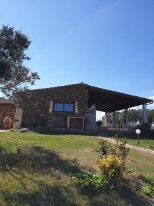 a brick house with a large window on a field at Cantina Perandria in Monti