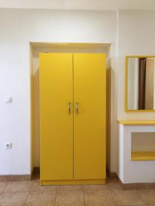 ein gelber Schrank in einem Zimmer mit Spiegel in der Unterkunft Apartment Gotovina Biograd na Moru in Biograd na Moru