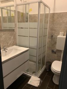 a bathroom with a shower and a sink and a toilet at Hotel Neyra Beach in Rimini