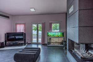 a living room with a fireplace and a fish tank at Villa Iris in Livadi