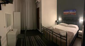 1 dormitorio con 1 cama y una pintura en la pared en Hotel Neyra Beach, en Rímini