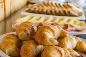 a plate of croissants and other pastries on a table at Sol del Nahuel - Hotel & Spa in San Carlos de Bariloche