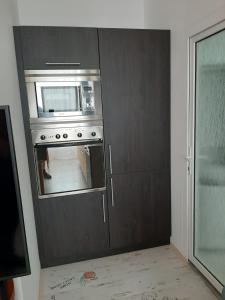 eine Küche mit einem Backofen und einer Mikrowelle in der Unterkunft Žlutý apartmán A6 v Chomutově in Chomutov