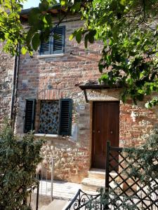 a brick building with a wooden door and windows at Central Lovely House in Montepulciano
