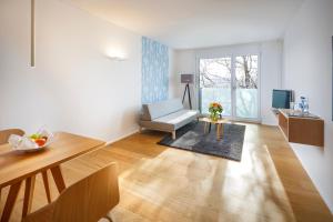 uma sala de estar com uma cadeira e uma mesa em APPADU Appartements em St. Gallen