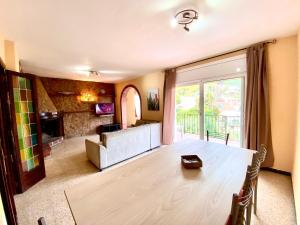 ein Wohnzimmer mit Tisch und Couch in der Unterkunft Casa con vistas al mar y piscina privada in Lloret de Mar