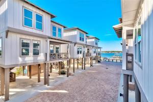a row of houses on a beach with the ocean at Blue Crab & Cool Breeze in Gulf Shores