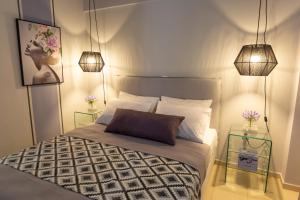 a bedroom with a bed with two end tables and two lamps at Jasmine - Apartment in Kalamata in Kalamata