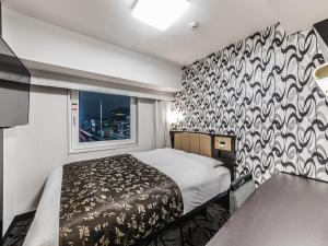 - une petite chambre avec un lit et une fenêtre dans l'établissement APA Hotel Shin-Osaka Esaka Ekimae, à Suita