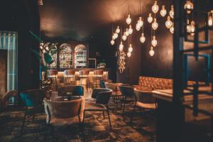 a restaurant with chairs and tables and lights at Dukes' Academie Brugge - by Dukes' Hotel Collection in Bruges