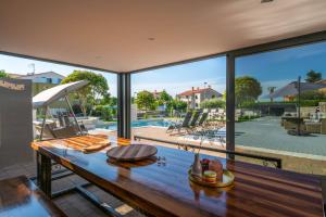 a large room with a table with a view of a pool at Villa Zorica in Poreč