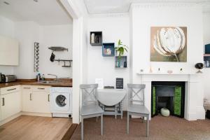 uma cozinha com uma mesa e cadeiras e uma lareira em Great family flat just 10 mins walk to beach em Portsmouth