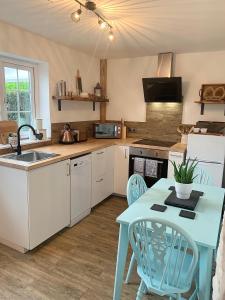 a kitchen with a blue table and a sink at Gorlan Cottage Tal y Bont Conwy in Conwy
