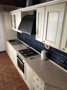 een keuken met witte kasten en een fornuis met oven bij Central Lovely House in Montepulciano