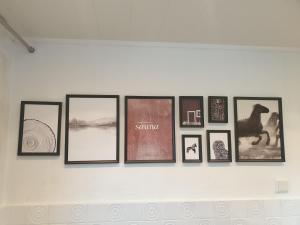 a group of framed pictures on a wall at Ferienwohnung Möwenblick in Flensburg