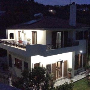 una gran casa blanca por la noche con luces en Skiathos Town House, en Skiathos