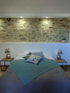 レ・ゼルビエにあるLes chambres d'hôtes de La Métairie du Bourgのベッドルーム1室(ベッド1台、ランプ付きテーブル2台付)