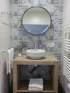 a bathroom with a sink and a mirror on a wall at Les chambres d'hôtes de La Métairie du Bourg in Les Herbiers