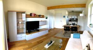 uma sala de estar com um sofá e uma televisão em Lake View Drobollach em Villach