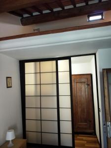 eine Glasschiebetür in einem Zimmer mit einer Decke in der Unterkunft Central Lovely House in Montepulciano
