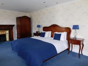 a bedroom with a bed and a dresser at Crow How Country Guest House in Ambleside
