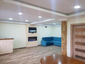 a living room with a blue couch and a fireplace at Vila Breza in Laktaši
