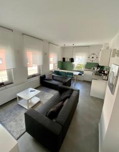 a living room with a black couch and a table at Ferienwohnung K1889 Rheine - Elin in Rheine