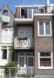 Una casa de ladrillo con un balcón en el lateral. en B&B La Festa en Ámsterdam