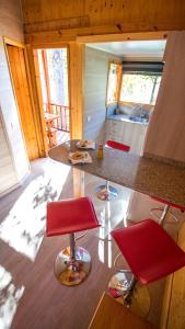 a kitchen with red chairs and a counter top at Camping Aneto in Benasque