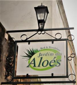 ein Schild an der Seite eines Gebäudes mit Licht in der Unterkunft Jardim dos Aloés, Unique B&B - Casa de Charme in Ilha de Moçambique