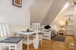 a white room with a table and chairs and a bed at Baza Bieszczady in Ustrzyki Dolne