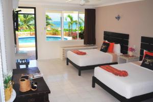 a hotel room with two beds and a view of the ocean at Hacienda Morelos Beachfront Hotel in Puerto Morelos