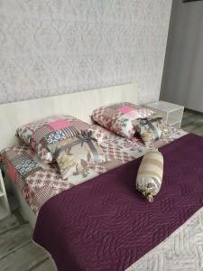 two beds in a bedroom with purple sheets and pillows at Mini Hotel na Leningradke in Kyiv