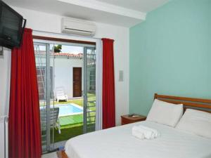 a bedroom with a bed and a television and a pool at Pousada Italia in Natal